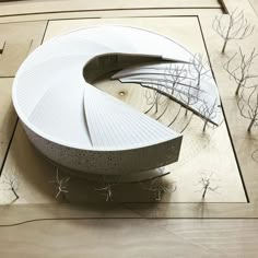 an architectural model of a circular building with trees in the foreground and on the ground