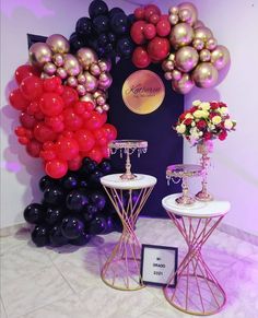 two tables with vases and flowers on them in front of a balloon wall display