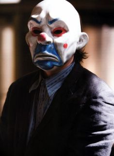 a man wearing a white mask with red eyes