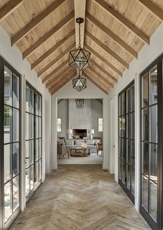 the inside of a house with wood flooring and large glass doors on both sides