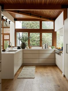 a kitchen with wooden ceiling and white cabinets