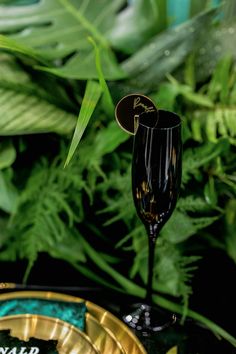 a black wine glass sitting on top of a gold plate