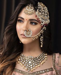 a woman in a bridal outfit with jewelry on her face