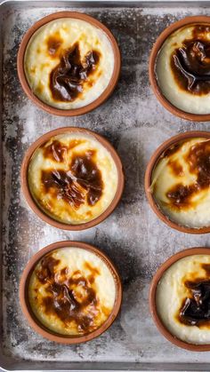 six cups filled with food sitting on top of a pan