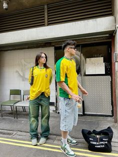 two people standing next to each other in front of a building with an open door