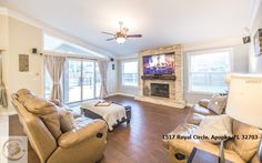 a living room with two couches and a flat screen tv on the wall in front of a fireplace