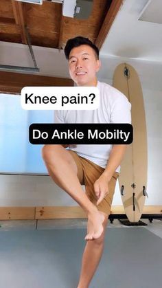 a man standing on one leg in front of a surfboard with the caption knee pain? do ankle mobility