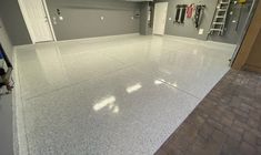 an empty garage with white floors and gray walls is seen in this image from the front door