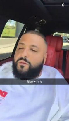 a man with a beard sitting in the back seat of a car