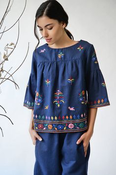 Navy blue top with all over Kutch inspired floral thread work.
Components: 1
Fabric: Cotton linen
Neckline: Wide
Sleeve Length: Three quarters
Color: Blue
Embroidery
Bell sleeves
Closure: Back buttons
Note: Pants worn by the model is not for sale - Aza Fashions Festive Tops With Geometric Embroidery, Blue Blouse With Geometric Embroidery For Spring, Festive Blue Embroidered Top With Intricate Details, Festive Blue Embroidered Top With Intricate Embroidery, Spring Blue Geometric Embroidered Blouse, Indigo Long Sleeve Tops With Floral Embroidery, Long Sleeve Indigo Tops With Floral Embroidery, Blue Tops With Geometric Embroidery For Spring, Bohemian Blue Tops With Intricate Embroidery