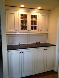 an empty kitchen with white cabinets and black counter tops in the center of the room