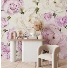 a room with flowers on the wall and two chairs in front of it, next to a table