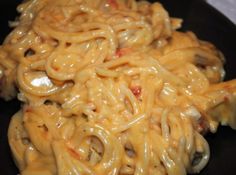 some noodles are being cooked on top of each other in a skillet with sauce