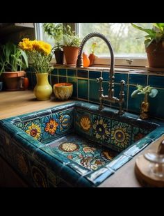 a sink in a kitchen with flowers and potted plants on the window sill