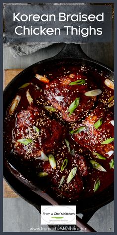 korean braised chicken thighs in a cast iron skillet with sesame seeds and green onions