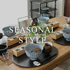 a wooden table topped with plates and bowls filled with food next to a potted plant