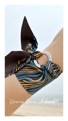 The Dionne mini silk scarf by Silk Philosophy. Statement accessories suitable for office and everyday wear. Unique gift for her. Multi-functional silk accessory. Wear it as a bracelet, ribbon in your hair, handbag charm or mini scarf or choker #wristscarf #birthdaygift #bracelet #armcandy #ootd #silkscarf #uniquegift #scarfbracelet #bangle #summeraccessories #wrapbracelet #giftideas Bohemian Style Silk Scarf For Gift, Luxury Silk Scarf As Gift, Luxury Silk Scarf Gift, Trendy Satin Silk Scarf Gift, Trendy Satin Silk Scarf As Gift, Satin Silk Scarf For Gift, Silk Scarf As A Gift, Trendy Silk Scarf As A Gift, Mini Scarf