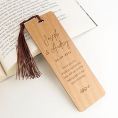 a bookmark with a tassel hanging from it's side next to an open book