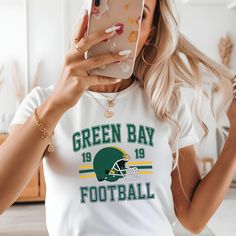 Elevate your game day style with our Green Bay Football Ladies Crop Top! Designed for true fans who want to showcase their team spirit, this trendy football crop top or football baby tee combines comfort and flair. This youth-size t-shirt is designed to acheive the classic '90s baby tee look. This is the Gildan 5000b youth tshirt. Please refer to size charts in the pictures for sizing information. Featuring the iconic Green Bay colors and a catchy design front and center, this crop top sports vibrant green and gold colors that make a bold statement. The stylish cut looks great paired with high-waisted jeans, shorts, or leggings. Make a fashion statement with this football game outfit or tailgate shirt! Whether you're tailgating, attending a game, or just showing off your Greenbay pride, th Cheap Green Tops For Football Season, Game Day Outfit Football, Football Wife Shirt, Football Crop Top, Football Wife, Football Outfit, Tailgate Shirt, Game Outfit, Football Game Outfit