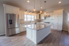 a large kitchen with an island and stainless steel appliances in the middle of the room