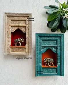 an elephant in a niche next to a potted plant on the side of a wall