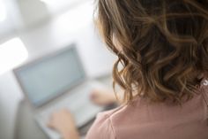 a woman using a laptop computer on her desk