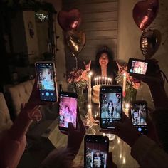 a group of people holding up cell phones in front of them with candles on them