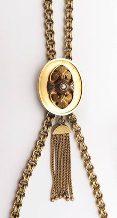 Presented is a beautifully hand crafted, Victorian 14 karat yellow gold chain necklace. This antique piece was made during the mid to late 1800s. The chain is done in a double loop or link form. The whole chain is completely hand made. The chain has a very decorative slider on it. The slider is set in the center with a natural pearl and there is a tassel dangling at the bottom. The tassel is in fabulous condition, which is very surprising for a piece of this age. This piece has been tested with Antique Formal Chain Necklaces, Antique Yellow Gold Chain Necklace For Formal Events, Antique Yellow Gold Chain Necklace For Formal Occasions, Elegant Antique Gold Chain Jewelry, Victorian Jewelry With Oval Link Gold Chain, Antique Oval Link Gold Chain Jewelry, Victorian Oval Link Gold Chain Jewelry, Antique Gold Chain Link Jewelry, Victorian Gold Chain Jewelry With Oval Links