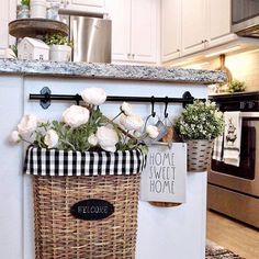 a basket with flowers in it hanging on the wall next to an oven and stove