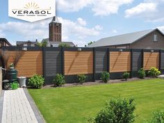 a fenced in yard with green grass and shrubs next to it is the logo for verasol