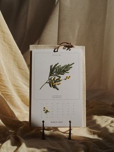 a calendar sitting on top of a table next to a wall hanging from a hook