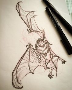 a drawing of a bat on paper next to two markers