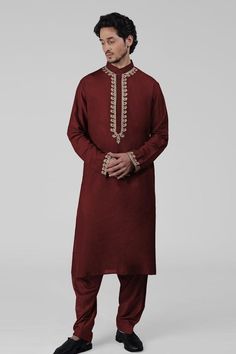 Maroon kurta featuring intricate tilla embroidery and delicate gold thread work on the front placket, sleeves, and neckline. Paired with a pathani salwar.
Components: 2
Pattern: Embroidered
Type Of Work: Tilla
Neckline: Band collar
Sleeve Type: Long
Fabric: Silk
Color: Maroon
Other Details: 
Attached lining
Length:
Kurta: 47 inches
Sleeve: 27 inches
Placket: 15.5 inches
Salwar: 42 inches
Occasion: Mehendi and Puja - Aza Fashions Navratri Long Sleeve Sherwani With Gota Work, Navratri Sherwani With Gota Work And Long Sleeves, Festive Straight Kurta Chanderi Bandhgala, Long Sleeve Raw Silk Kurta With Gota Work, Festive Bandhgala With Gota Work In Straight Kurta Style, Transitional Bandhgala With Gota Work And Long Sleeves, Festive Bandhgala With Gota Work, Transitional Long Sleeve Bandhgala With Gota Work, Designer Navratri Kurta With Gold Embroidery