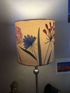 a lamp that is sitting on top of a table next to a vase with flowers