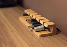 a wooden shelf with several different types of electronic gadgets on it, and one is plugged into the wall