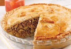 a pie that has been cut in half and is sitting on a table next to an apple