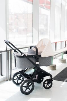 a baby stroller sitting in the middle of an airport terminal waiting to be picked up