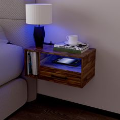 a bedside table with a phone on it next to a lamp