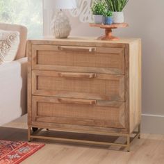 a wooden dresser with two drawers and a potted plant sitting on top of it