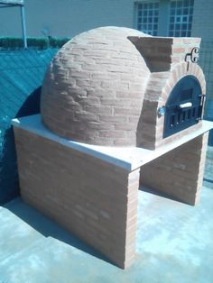 an outdoor brick pizza oven sitting next to a swimming pool