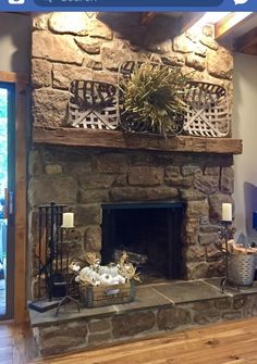 a stone fireplace in a living room with wood flooring