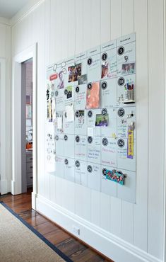 a bulletin board with pictures and magnets on it in the corner of a room