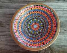 a wooden bowl sitting on top of a wooden table next to a piece of wood