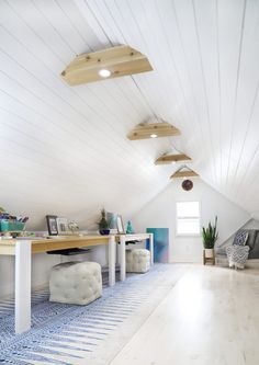 a room with white walls and wooden ceilings, blue patterned rugs on the floor