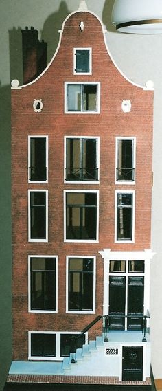 a model of a brick building with windows and balconies on the top floor