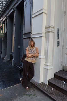 a woman leaning against the side of a building