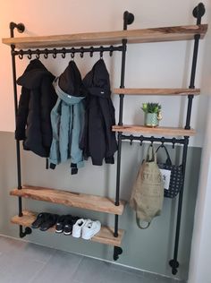 a coat rack with several coats hanging on it and shoes in the bottom shelf below