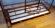 a bird cage sitting on top of a wooden floor