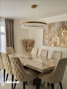 a dining room table with white chairs and a chandelier hanging from the ceiling