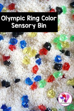 the olympic ring color sensory bin is full of colorful beads and plastic rings on top of white rice